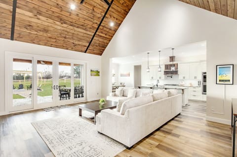 Cozy up on our comfortable couch with breathtaking views of the fire pit area and the stunning countryside beyond, as you unwind and enjoy the beauty of nature through the massive double slidi