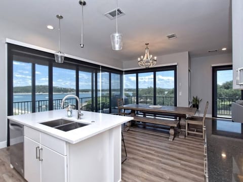 - Open dining area with lakeview windows for scenic mealtime moments - Stylish lighting enhances bright kitchen flow and vacation comfort - Spacious layout blends indoor outdoor living for easy getaway joy
