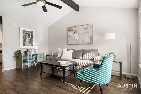 Large and open living room with sleeper sofa, smart tv, and work desk