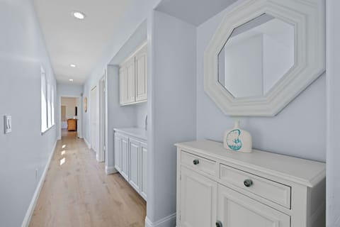 Hallway with coastal charm that connects to the bedrooms