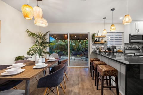 Dining table with extra seating in large kitchen island facing lush patio