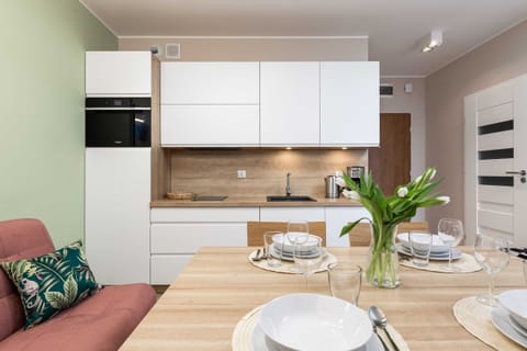 A compact and modern kitchen with an electric kettle, coffee maker, and sleek appliances.
