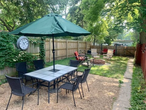 Backyard: dining table, lights, grill, and bench swing, fire pit