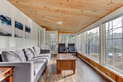 Enjoy natural light and scenic views from this spacious sunroom, complete with comfy seating and warm wood finishes.