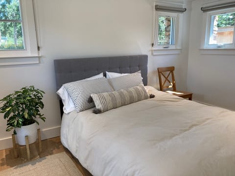 Queen bed and custom roller shades for a good night's sleep.