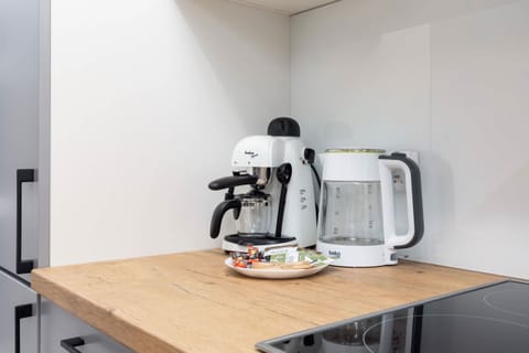 A compact dining table with a coffee maker and cups for morning convenience.