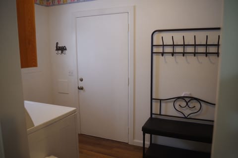 A barn door separates the bathroom from the laundry/mud room