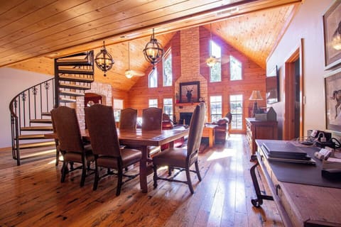 Main Lodge - Dining and Lounge. Gather around the big, beautiful wooden table in the main lodge's dining area, featuring six comfortable chairs—perfect for family meals and creating lasting memories together.