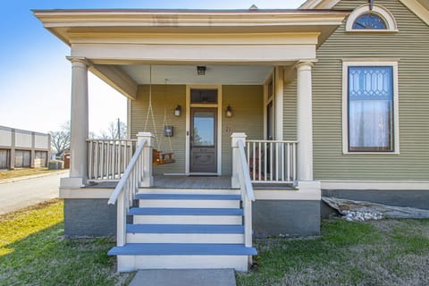 Front porch has a porch swing and a pair of Adirondack chairs.