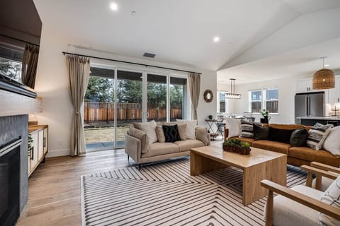 Living area with a 65 inch smart TV, SONOS surround sound system, gas fire place, board games.