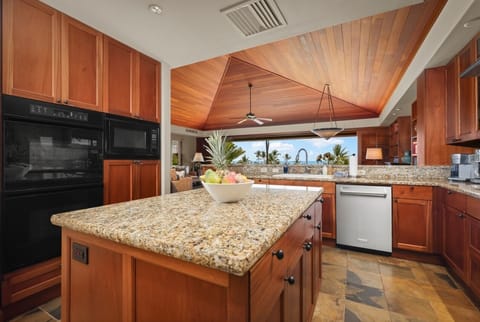 Ocean view kitchen with gleaming granite countertops and top tier appliances.