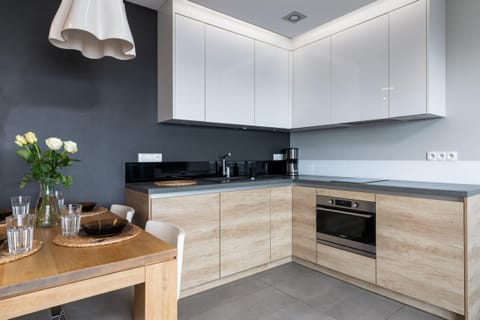 A modern kitchen with sleek wooden cabinets, offering a spacious and functional cooking space with integrated appliances.
