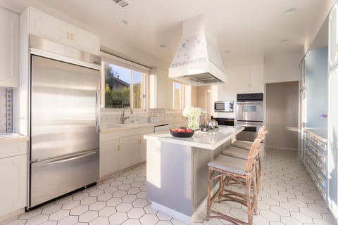 The kitchen features an island and state of the art appliances.