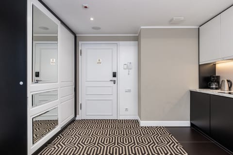 A hallway with mirrored cabinets, stylish flooring, and modern lighting.