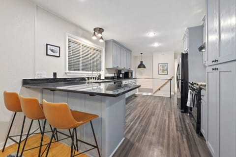 To the right, you'll see three leather barstools overlooking the kitchen.