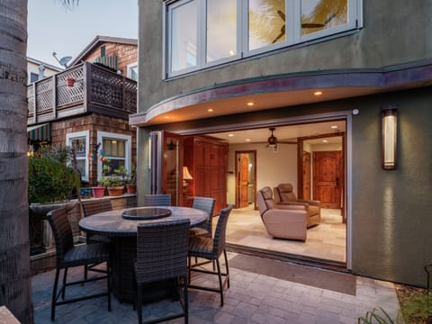 This inviting outdoor patio features a round dining table with wicker chairs, perfect for al fresco dining.