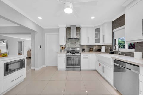 The large open kitchen is equipped with state of the art appliances for every gourmet chef. Extra counter space and a perfect view of the living room, dining room, and backyard oasis.