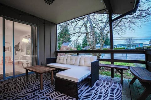 The living room leads to a covered deck equipped with comfortable outdoor furniture, offering a relaxing space to unwind