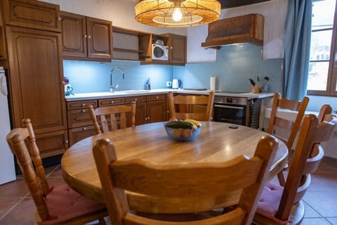 Fully equipped kitchen with microwave, oven, electric hob and a large dining table.