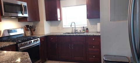 Modern kitchen with gas stove and Samsung smart refrigerator.