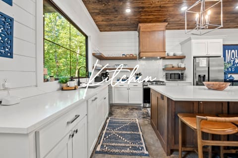 This bright and airy kitchen makes cooking a delight with plenty of counter space and large windows that bring the outdoors in.