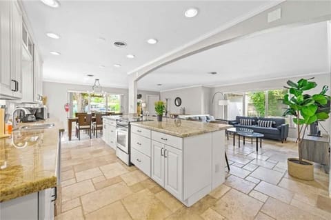 Open layout kitchen with island. Full set of appliances, including a Keurig coffee maker and basic kitchen utensils.