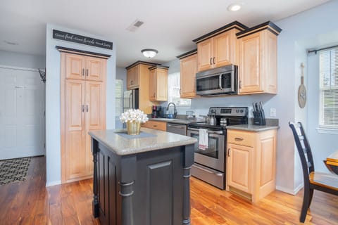 A perfect blend of natural beauty and contemporary design in this kitchen with wooden floors and a black island.