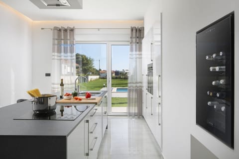 Fully equipped kitchen area of Medulin pool villa with wine cooler and stove for family vacation