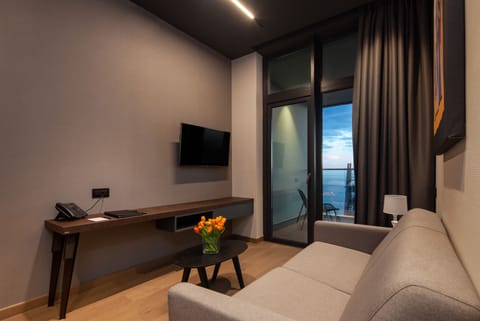 Standard Suite | Living area | Flat-screen TV, books