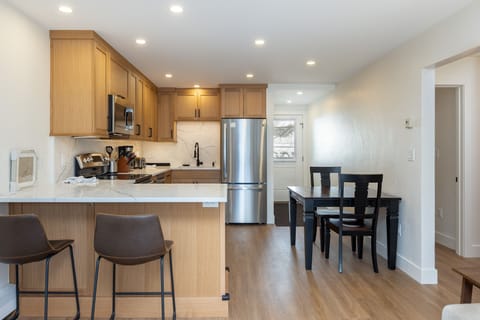 The eat-in kitchen offers a dining table for two and a breakfast bar with seats two more.