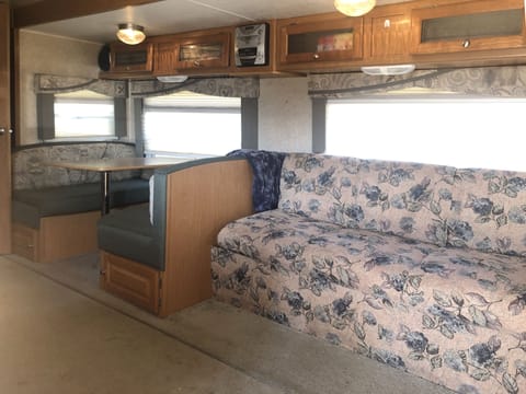 Inside RV, sofa and dining area.