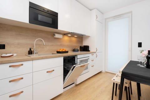 Fully equipped kitchenette with a dishwasher, oven, coffee machine, kettle, induction hob, fridge and microwave.