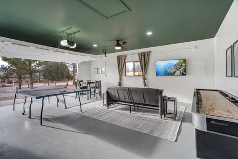 Perfect for family/friendly game nights, the garage game room is incredibly equipped with a ping pong table, shuffleboard, a large Smart TV, and a futon for additional relaxation..