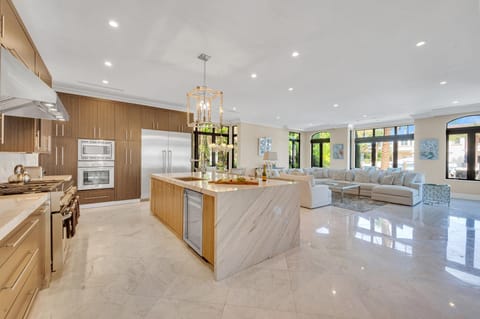 The gourmet kitchen opens on the family room and breakfast nook featuring incredible views of the canal and heated pool.