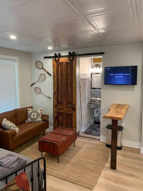 Character abounds throughout this space.  Notice the live edge bar height counter, as well as the antique sliding door.  In the rear of the photo is a shot of the bathroom with full sized shower, sink and toilet. 