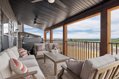 Main Level Deck with seating, hot tub, lakeview, and grill