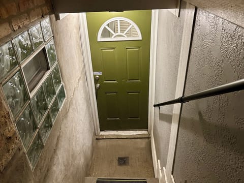 Porch light illuminating stairway to unit at night.