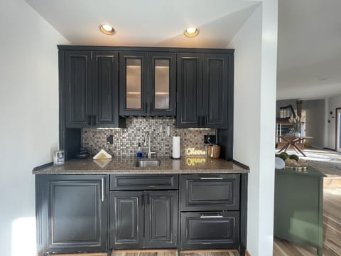 wet bar with a large wine/drink refrigerator and two drawer refrigerators. 