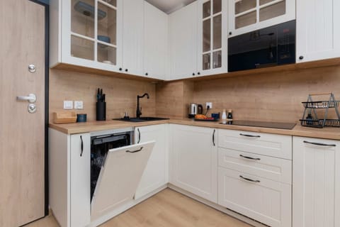 A close-up of the kitchen cabinets, showing an assortment of cups and neatly organized shelving.

