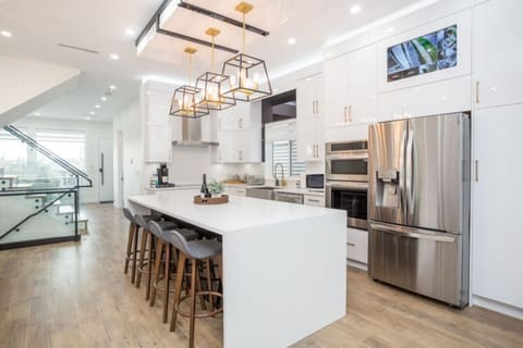 Stylish and fully equipped kitchen with a fridge, oven, and dishwasher, complemented by a beautiful island that’s perfect for meal prep or casual dining with family and friends.