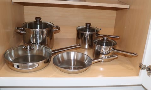 Pots and pans, cutting boards, utensils, a fresh cleaning sponge, and dish soap.