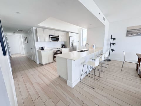 Fully equipped kitchen with stainless steel appliances and a stylish backsplash.