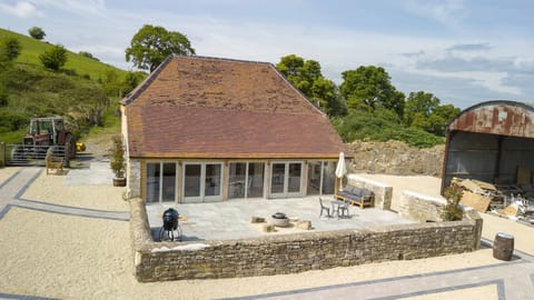 Large patio with chairs, outside sofa bed and charcoal BBQ