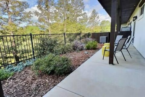 Kitchen opens to a serene patio with chairs, tables, and olive orchard views—ideal for relaxing.