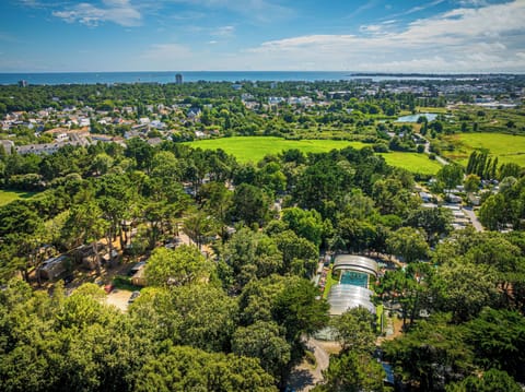 Soak in stunning views of La Baule from above, where lush greenery surrounds the resort’s outdoor amenities and hints at a laid-back camping vibe.