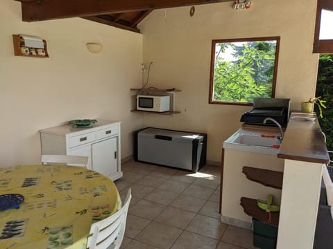 Summer kitchen next to the pool with plancha BBQ, Fridge, Microwave and sink.