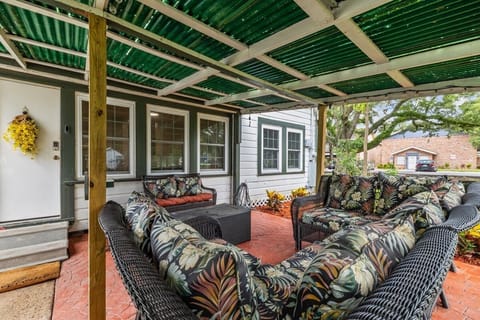 Covered porch with glider chair for 2 and nice outdoor patio set. Table is actually an ice chest!