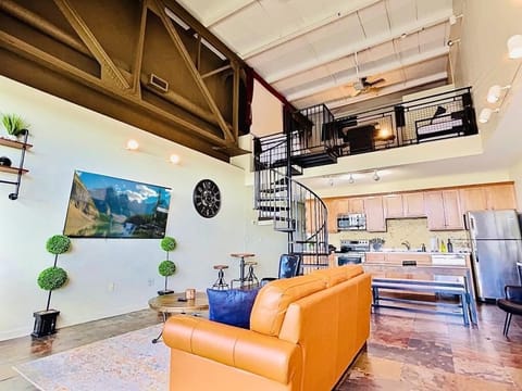Step into the lower level of the condo and behold its distinctive stone flooring, adding a touch of rustic charm to the space. Your eyes are drawn to the striking spiral staircase, an architectural masterpiece that leads you up into the loft area.