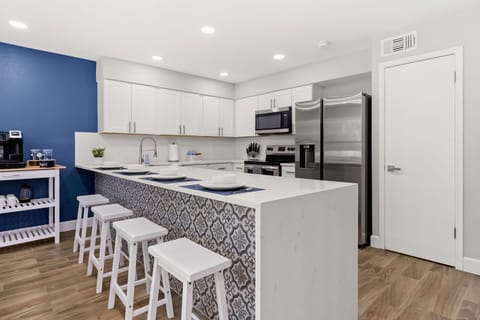Gather around the stylish kitchen bar, a perfect spot for casual dining, socializing, and enjoying a morning cup of coffee.