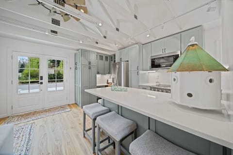 Modern updated kitchen featuring sleek stainless steel appliances, a spacious layout, and a stylish kitchen island with barstool dining—perfect for meals and gathering.